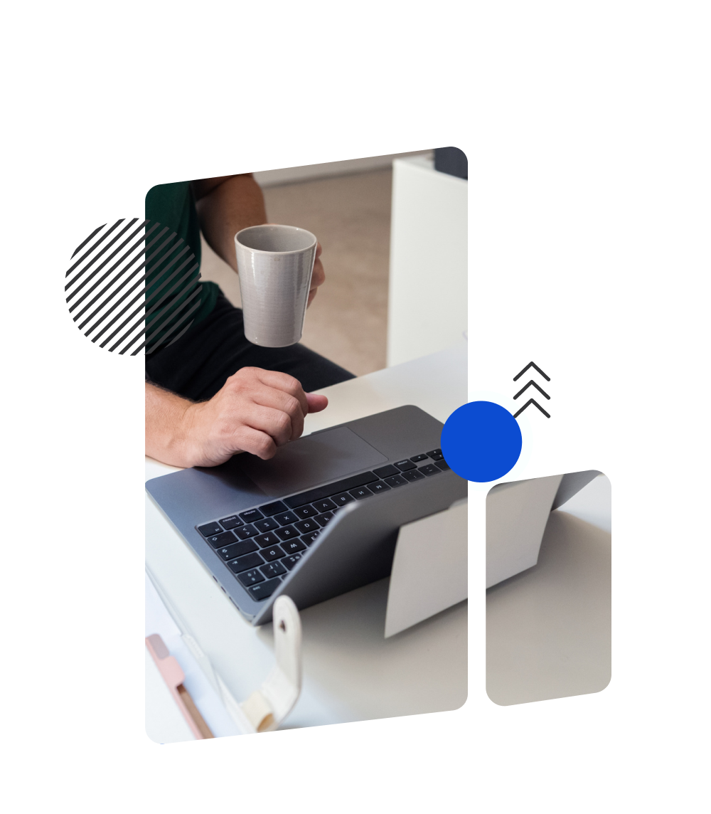 Person holding a mug while using a laptop, preparing for mobile accessibility testing.