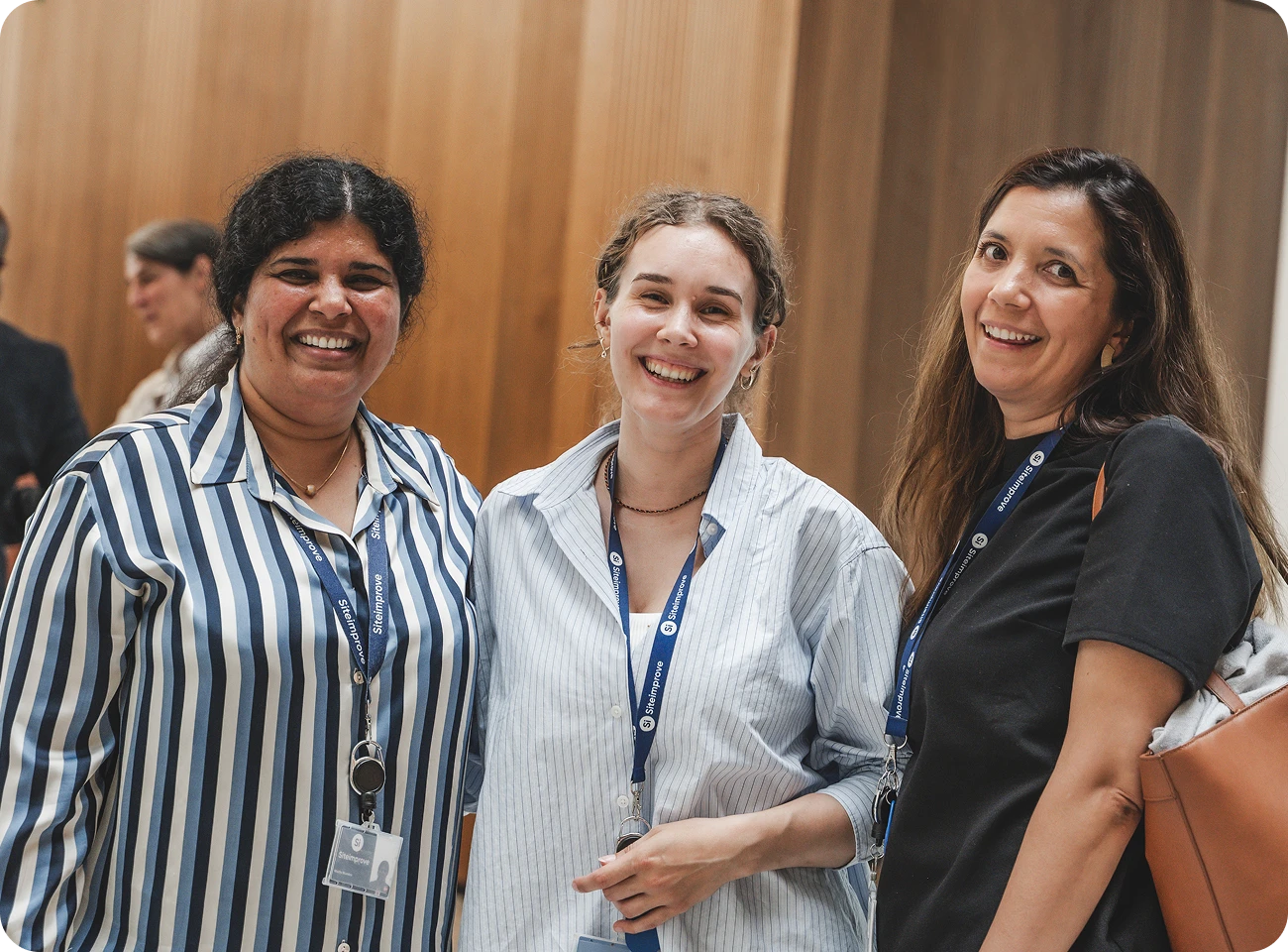 Three Siteimprovers smiling together in an office.